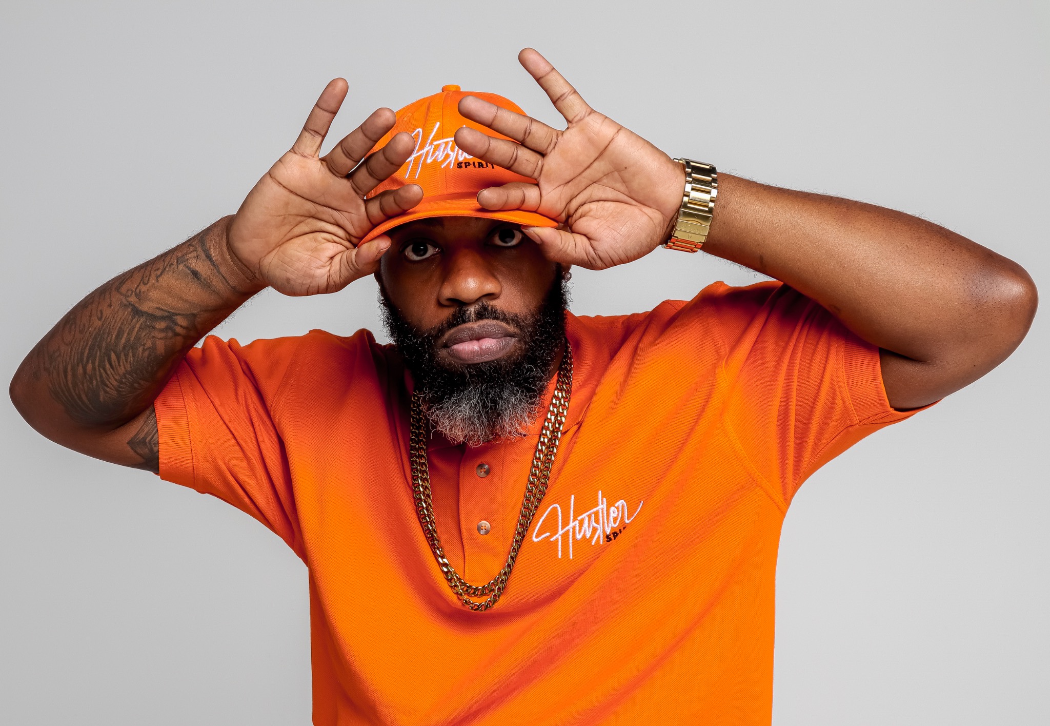 Hustler Spirit model wearing an orange shirt and printed bucket hat